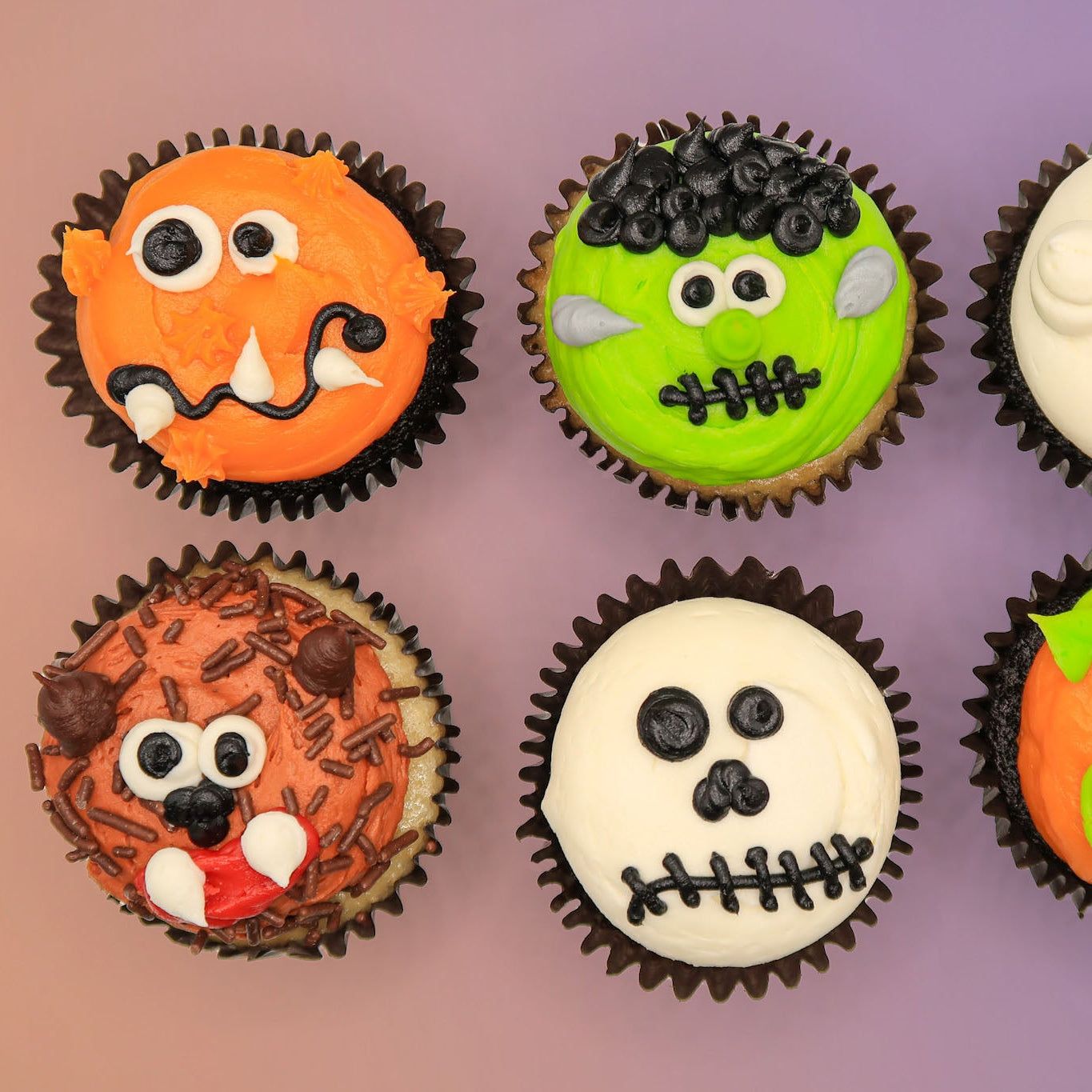 Six Halloween-themed cupcakes with different designs on a purple background